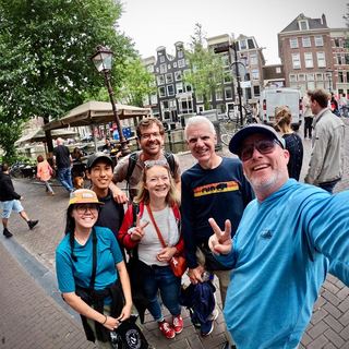 A small group with Dennis in front of a historic Amsterdam house